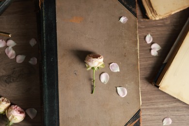 Photo of Books, beautiful flower buds and petals on wooden table, flat lay