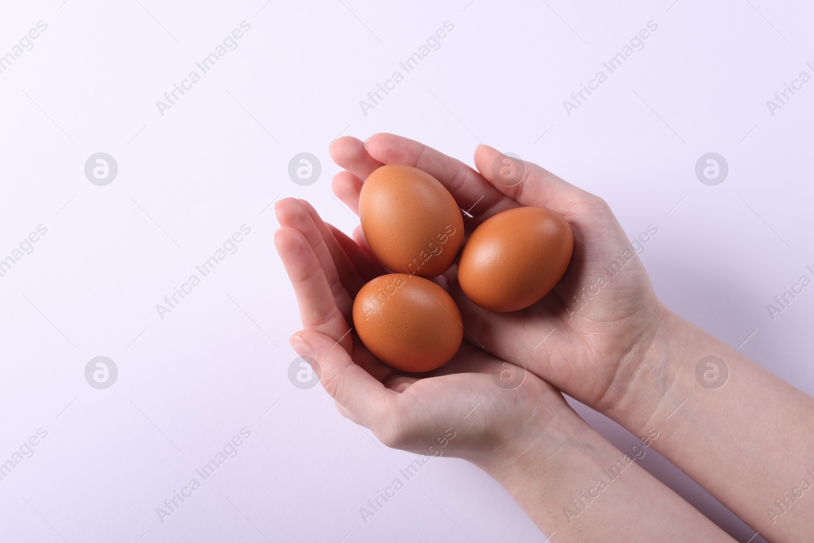 Photo of Woman with raw eggs on light background, closeup