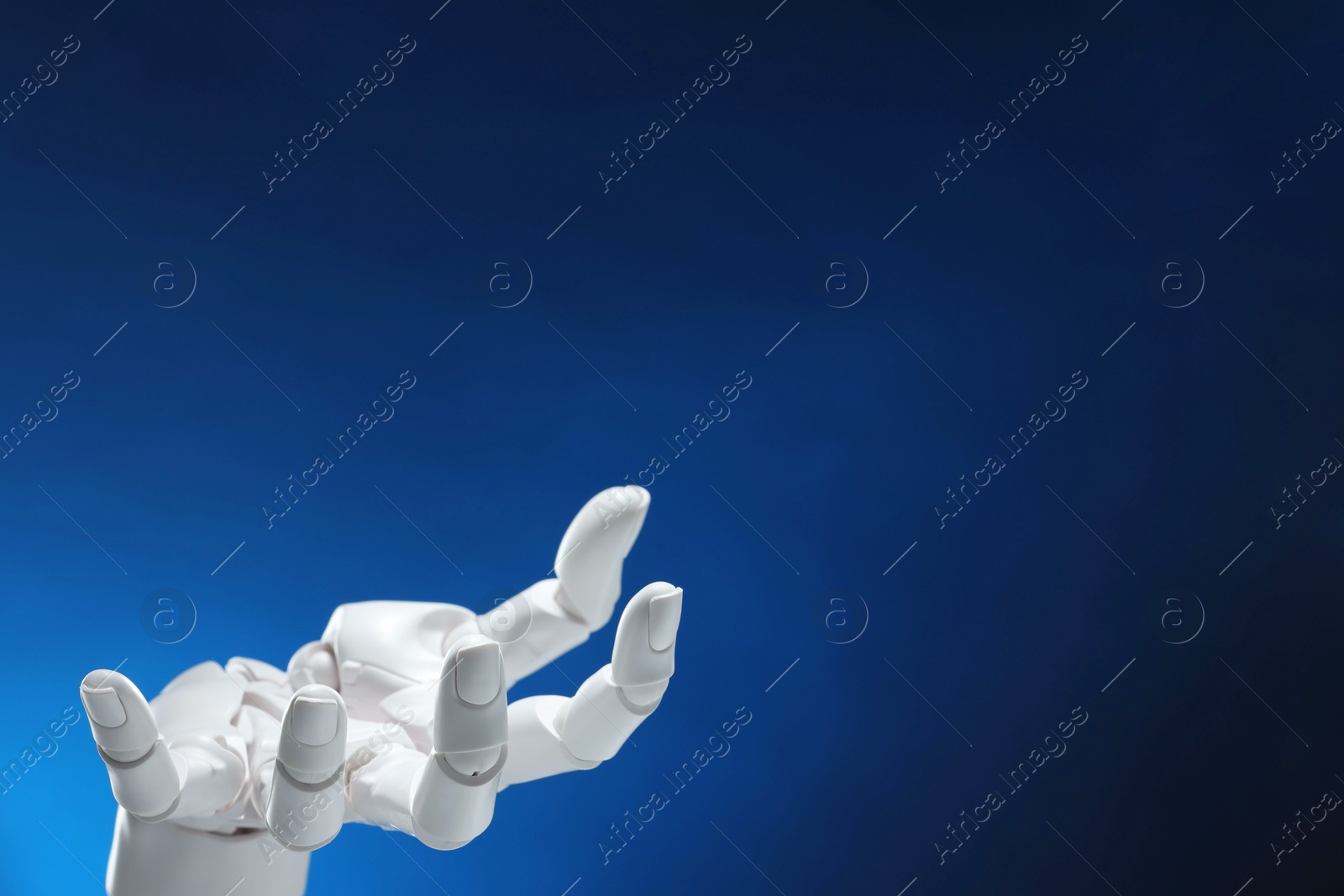 Photo of Artificial intelligence. Robot hand gesturing on dark blue background, space for text