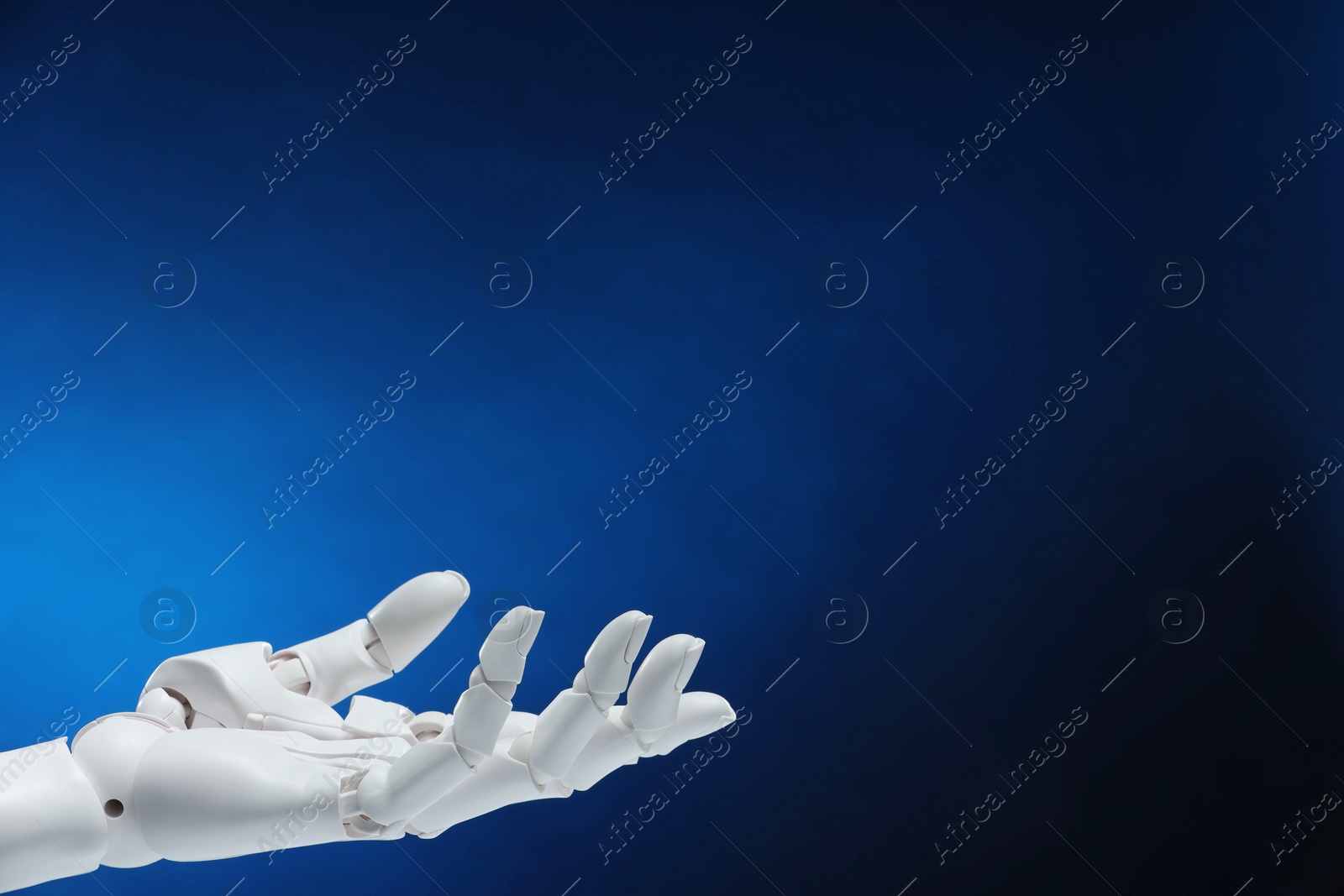 Photo of Artificial intelligence. Robot hand gesturing on dark blue background, space for text