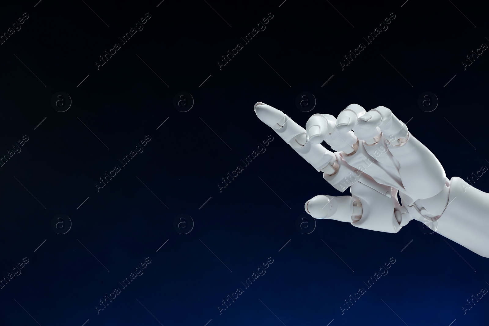 Photo of Artificial intelligence. Robot hand pointing at something on dark blue background, space for text