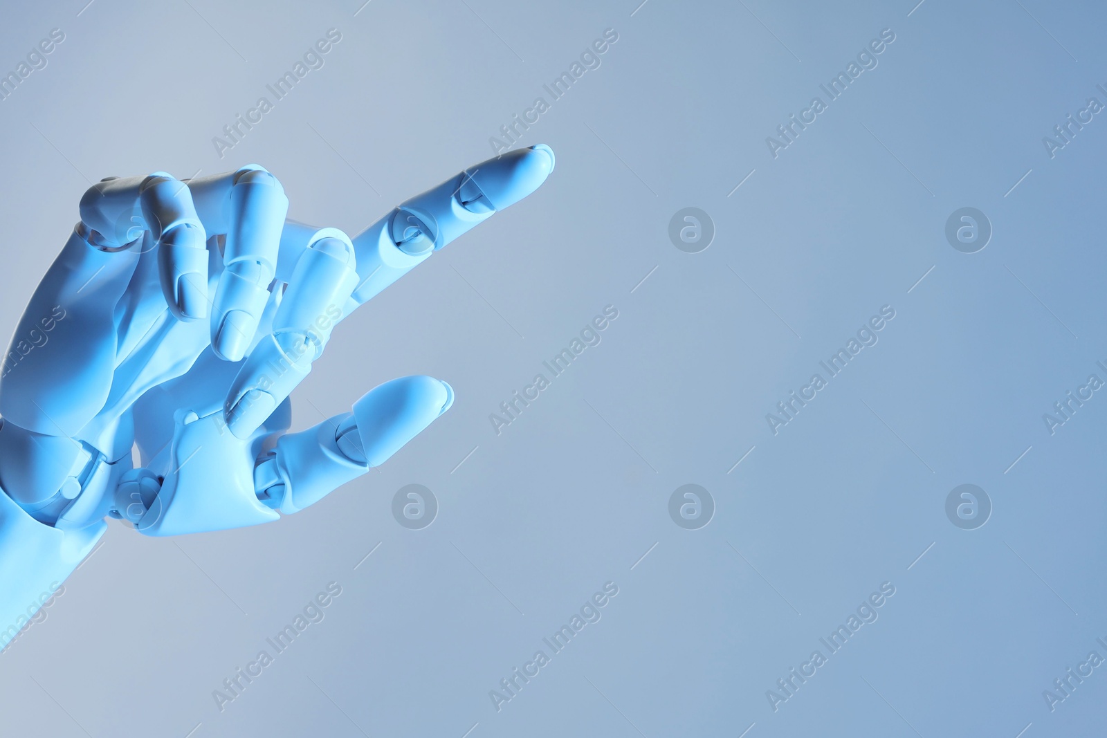 Photo of Artificial intelligence. Robot hand pointing at something on pale light blue background, space for text