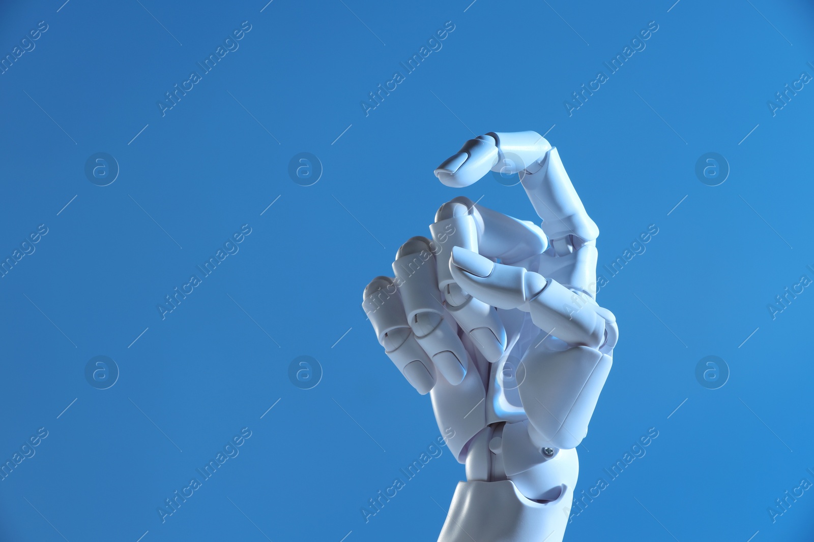 Photo of Artificial intelligence. Robot hand gesturing on blue background, space for text