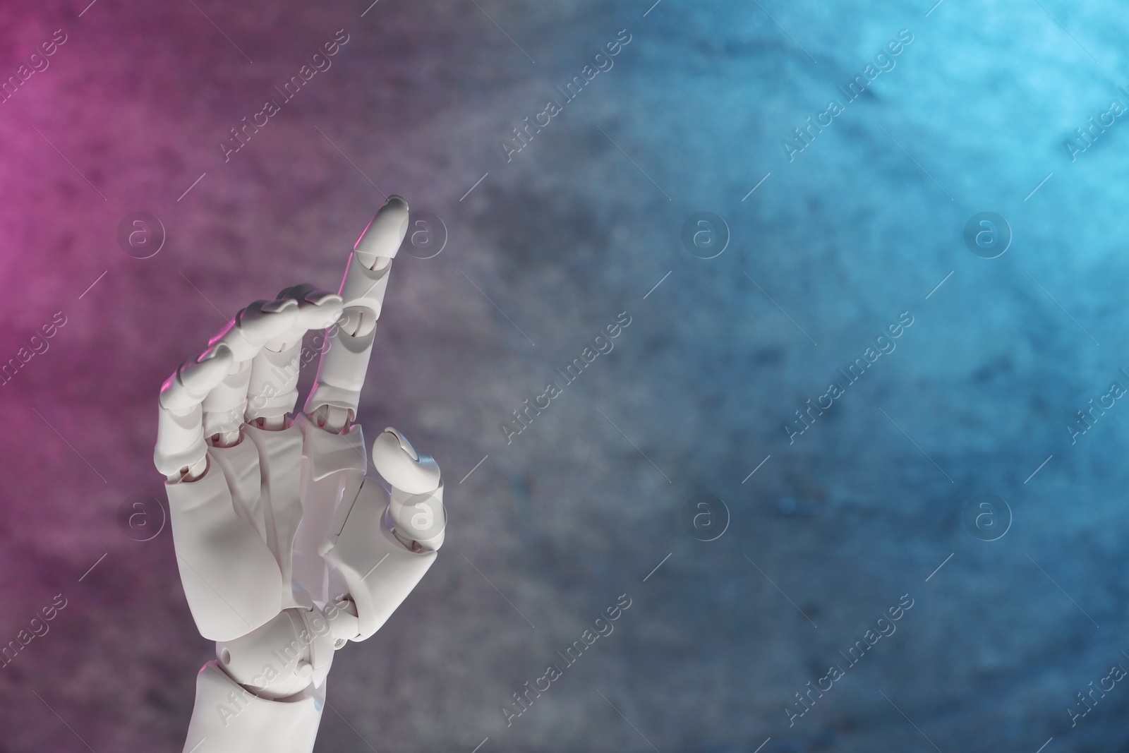 Photo of Artificial intelligence. Robot hand gesturing on grey background in neon lights, space for text