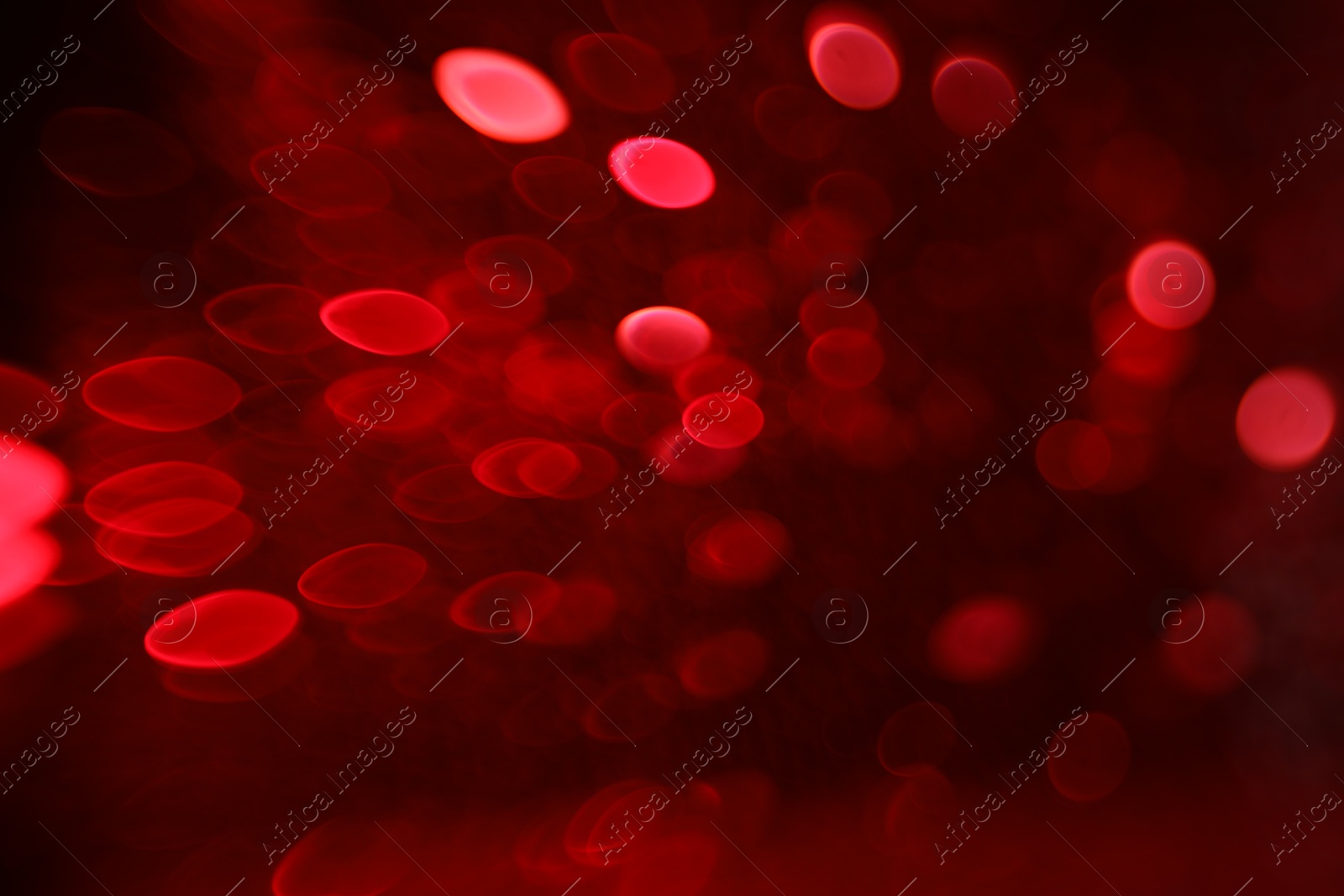 Photo of Blurred view of festive lights on red background. Bokeh effect