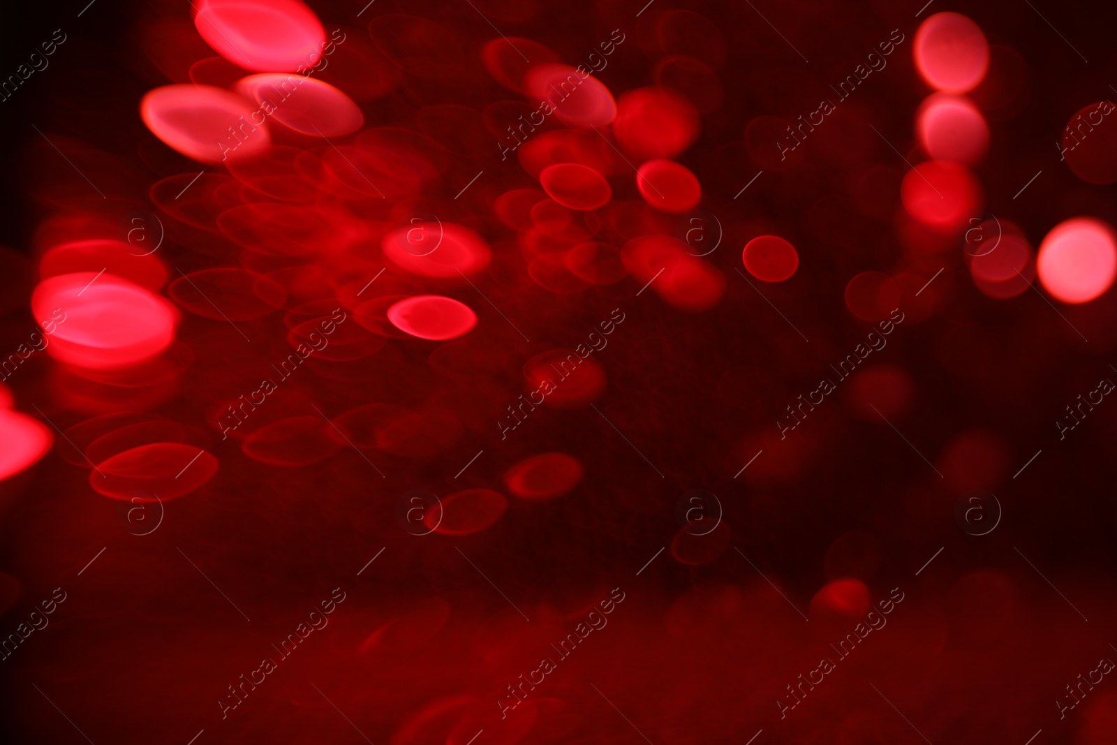 Photo of Blurred view of festive lights on red background. Bokeh effect