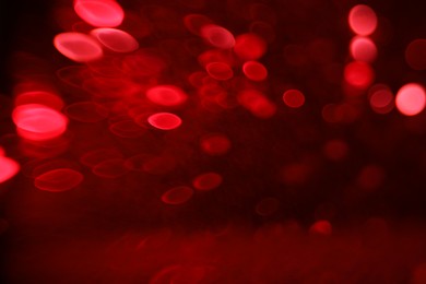 Photo of Blurred view of festive lights on red background. Bokeh effect