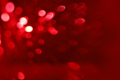 Photo of Blurred view of festive lights on red background. Bokeh effect