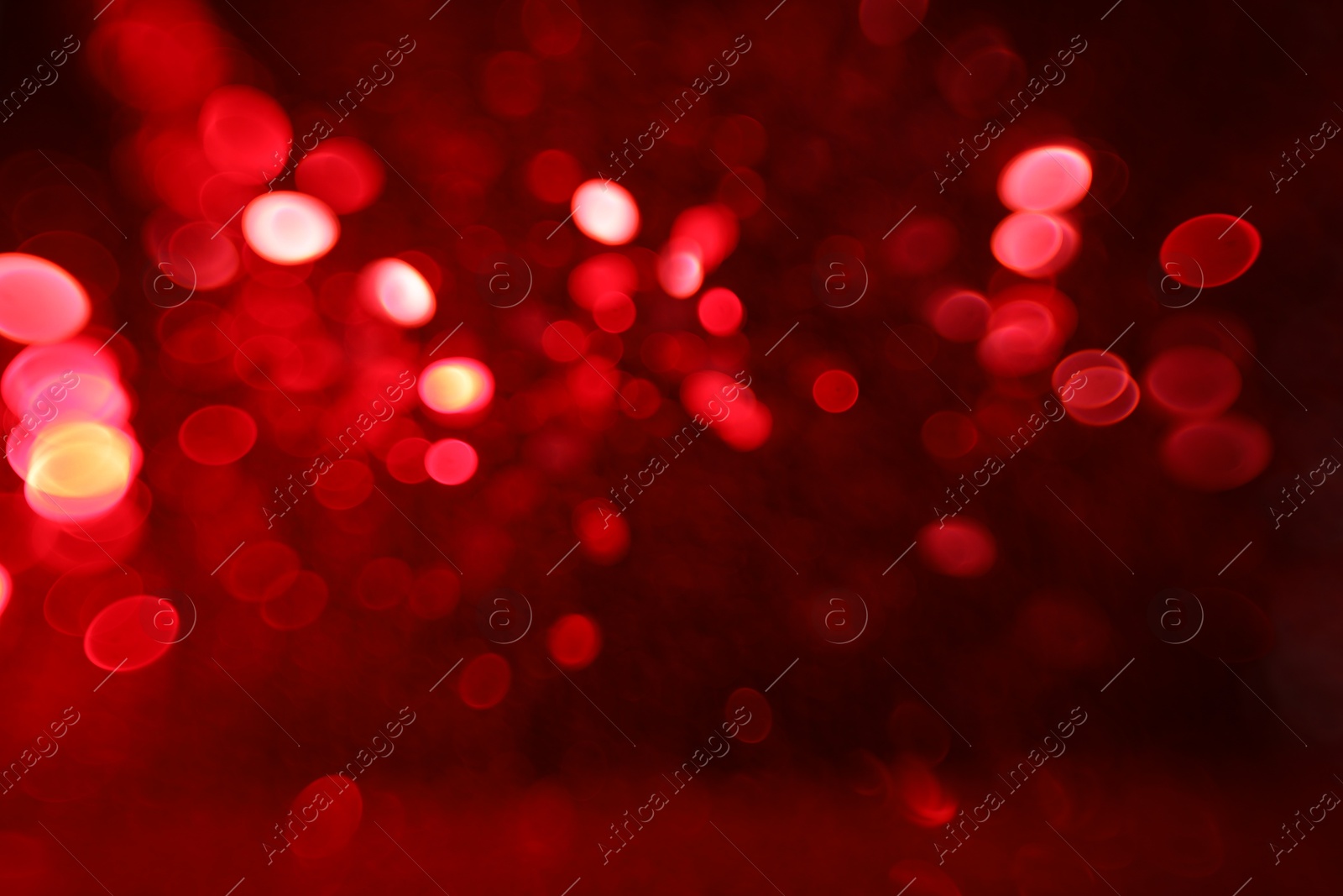 Photo of Blurred view of festive lights on red background. Bokeh effect