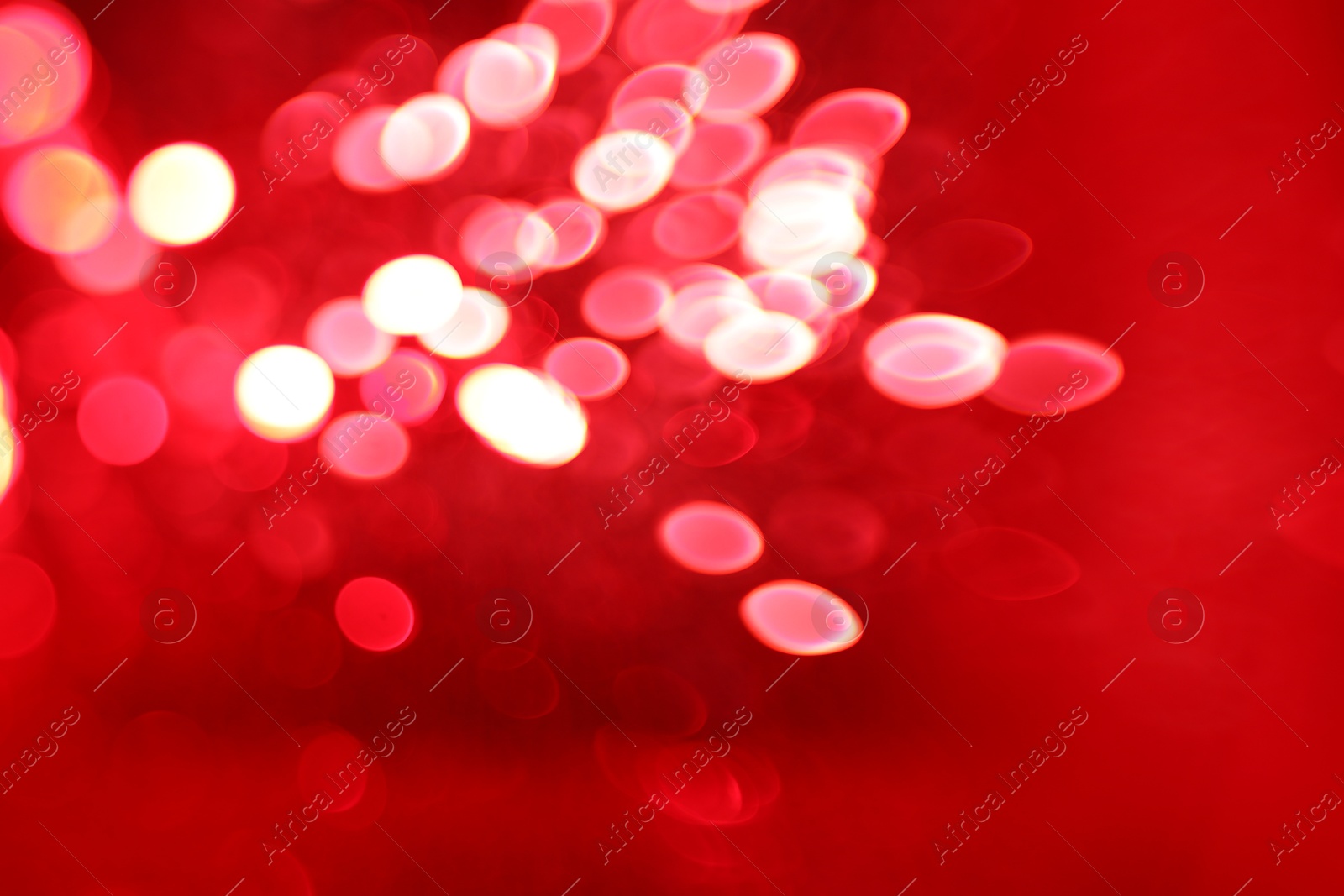 Photo of Blurred view of festive lights on red background. Bokeh effect