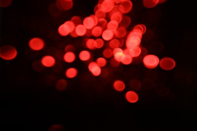 Photo of Blurred view of festive lights on black background. Bokeh effect