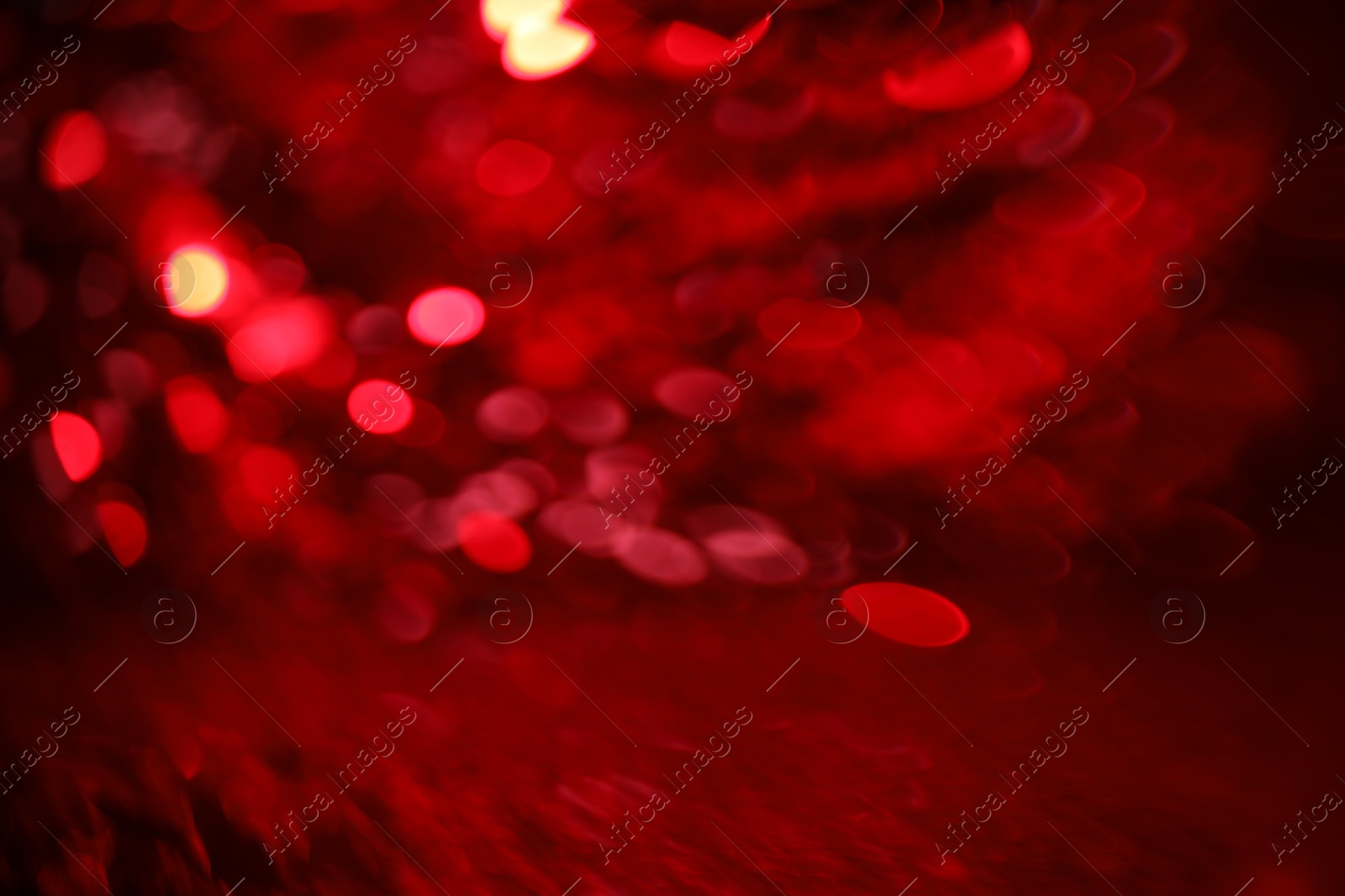 Photo of Blurred view of festive lights on red background. Bokeh effect