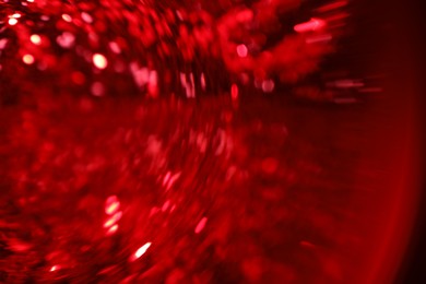 Photo of Blurred view of festive lights on red background. Bokeh effect