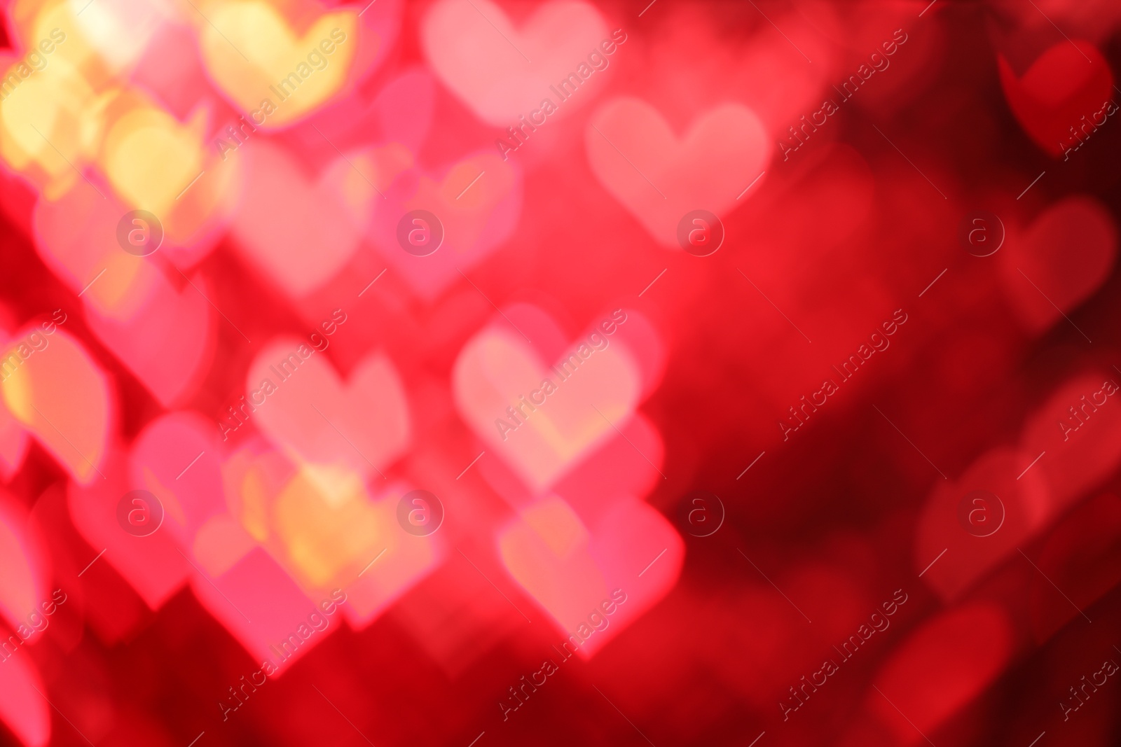 Photo of Romantic decor. Blurred view of heart shaped lights on red background, bokeh effect