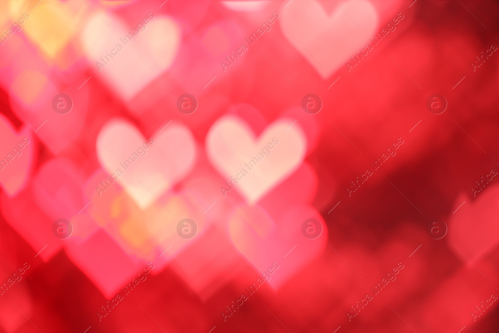 Photo of Romantic decor. Blurred view of heart shaped lights on red background, bokeh effect