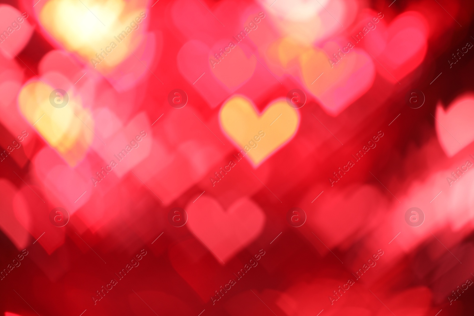 Photo of Romantic decor. Blurred view of heart shaped lights on red background, bokeh effect