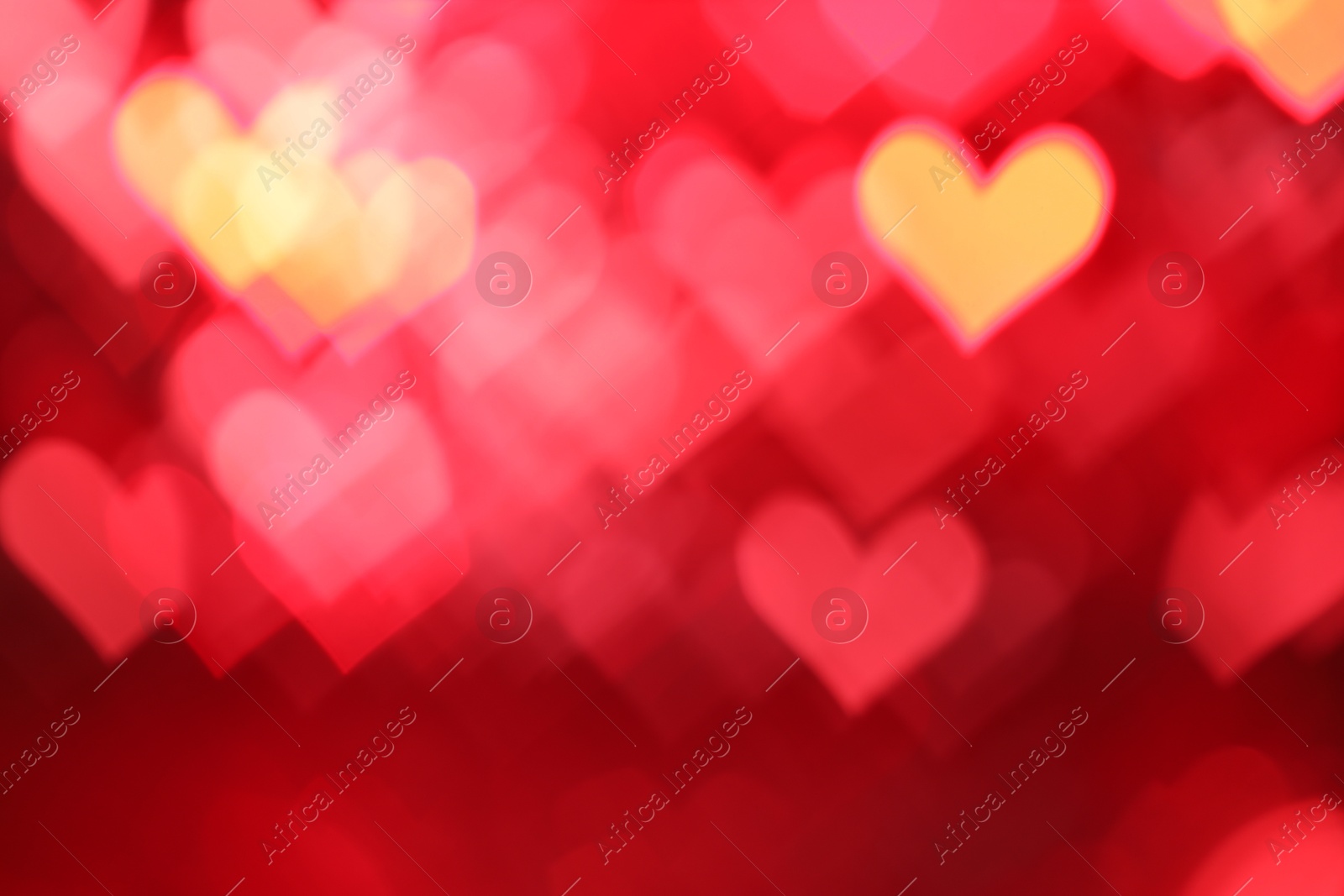 Photo of Romantic decor. Blurred view of heart shaped lights on red background, bokeh effect