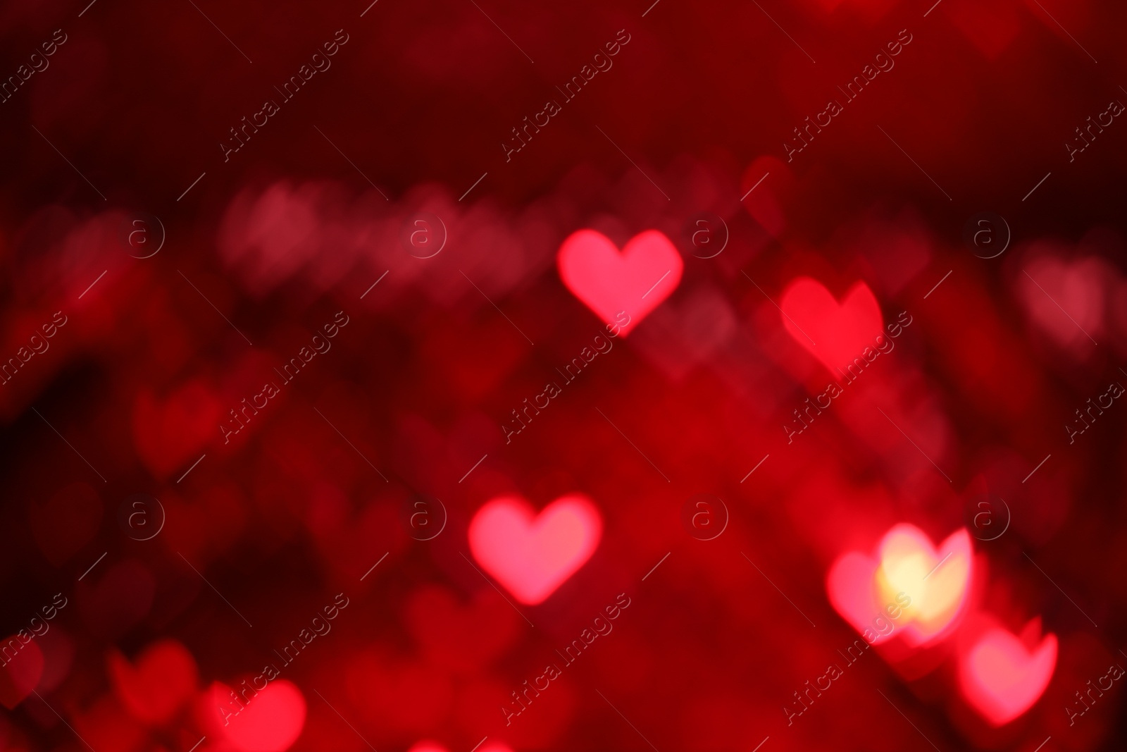 Photo of Romantic decor. Blurred view of heart shaped lights on red background, bokeh effect