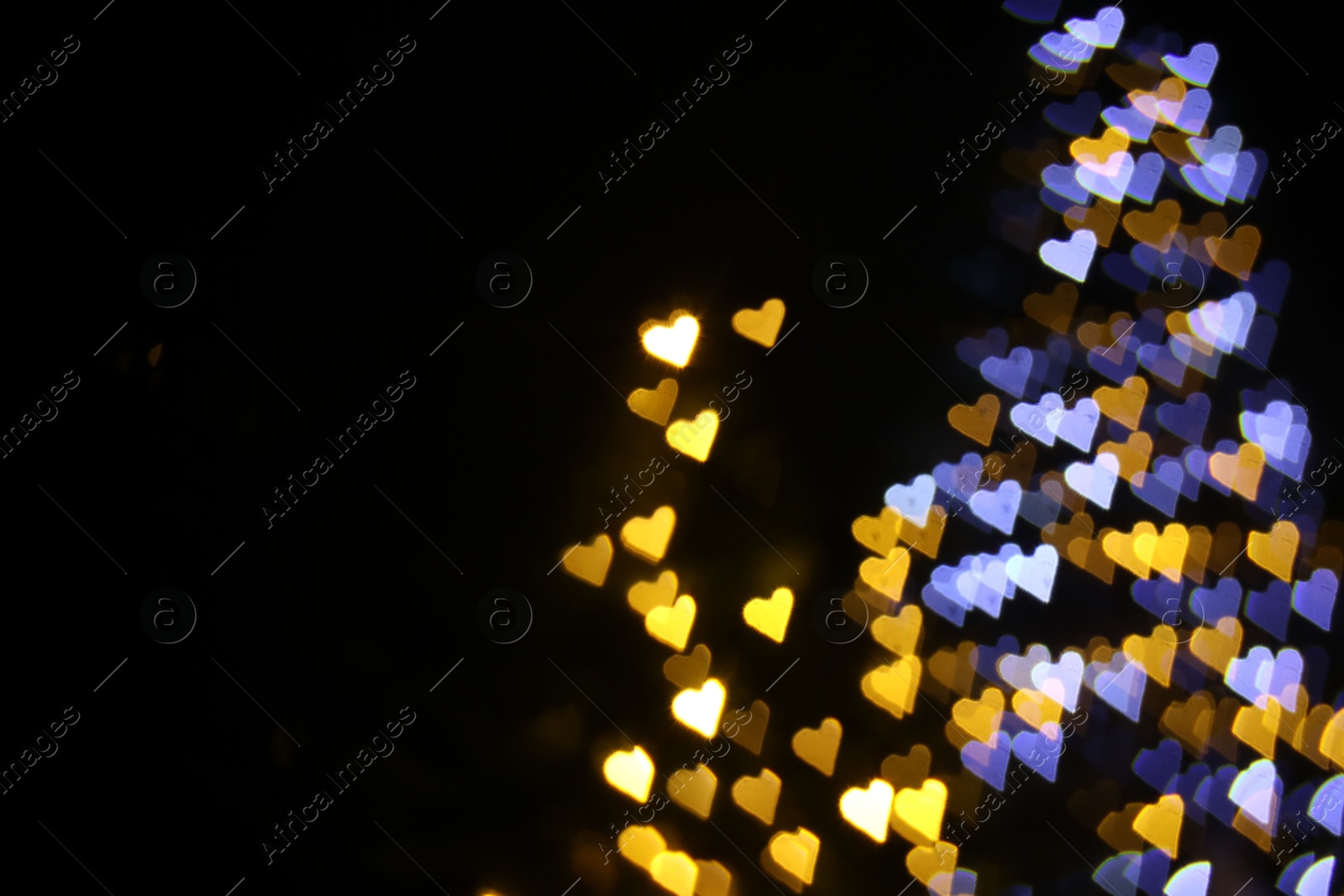 Photo of Romantic decor. Blurred view of heart shaped lights on black background, space for text. Bokeh effect