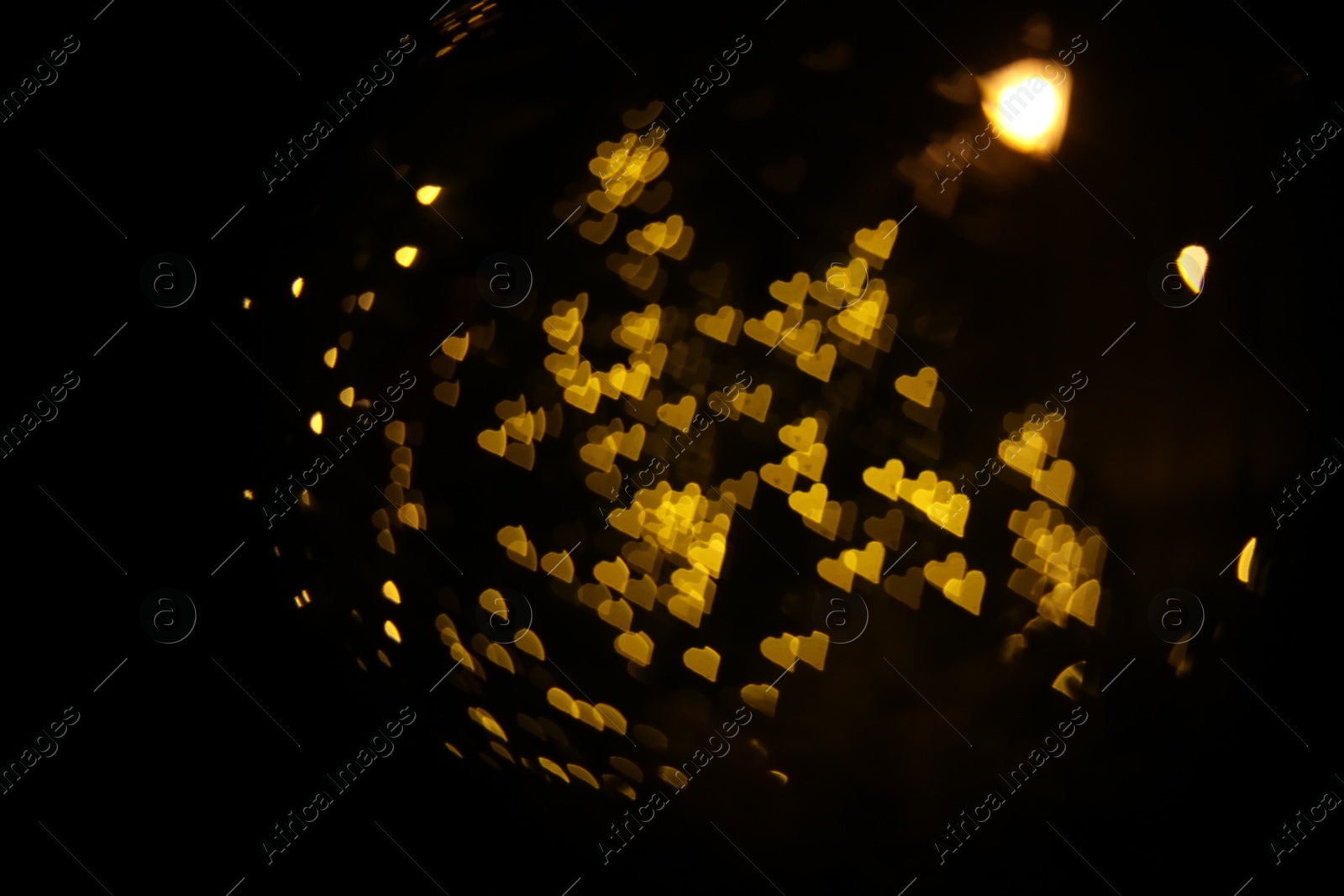 Photo of Romantic decor. Blurred view of heart shaped lights on black background, bokeh effect