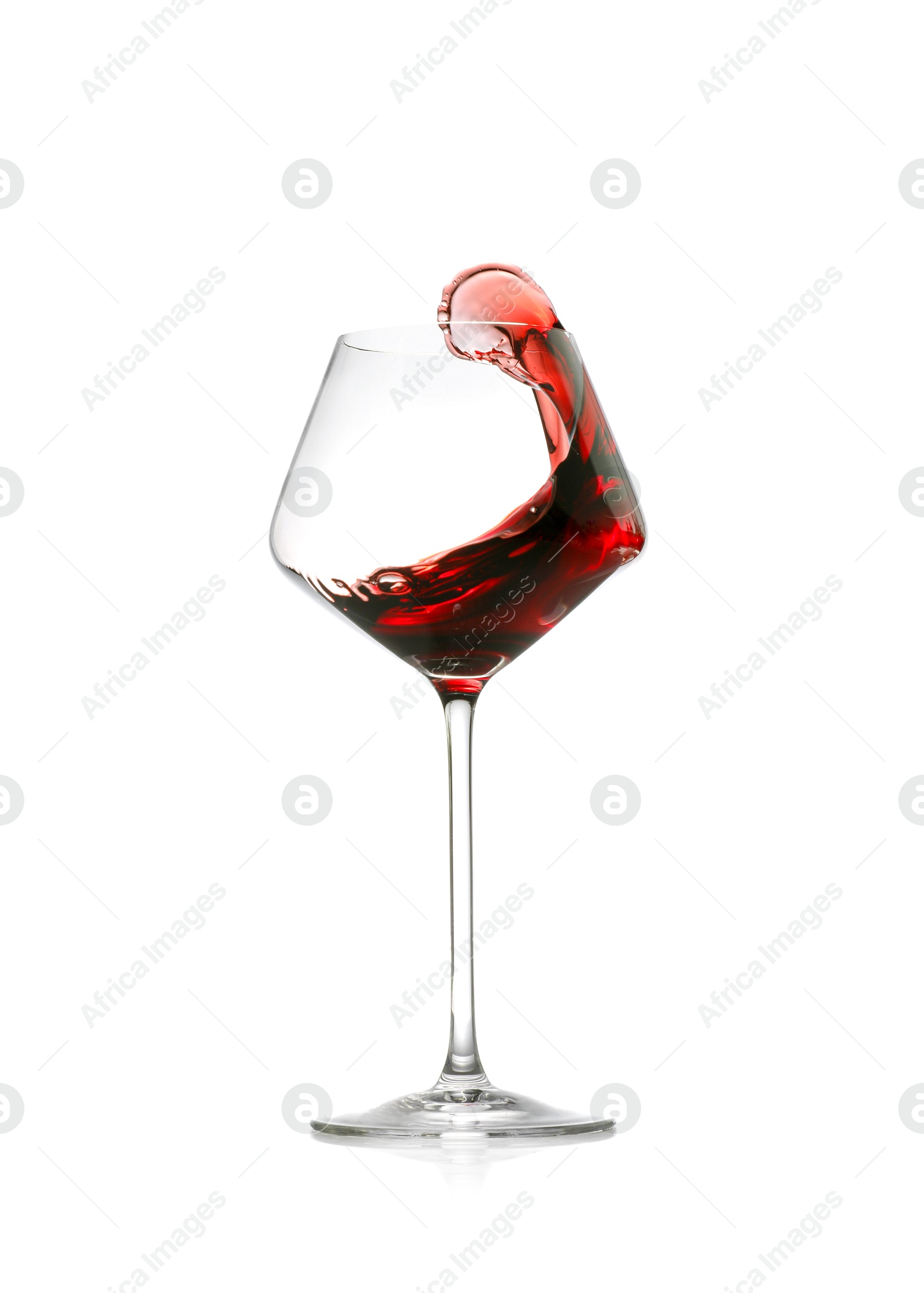 Photo of Red wine splashing in glass on white background