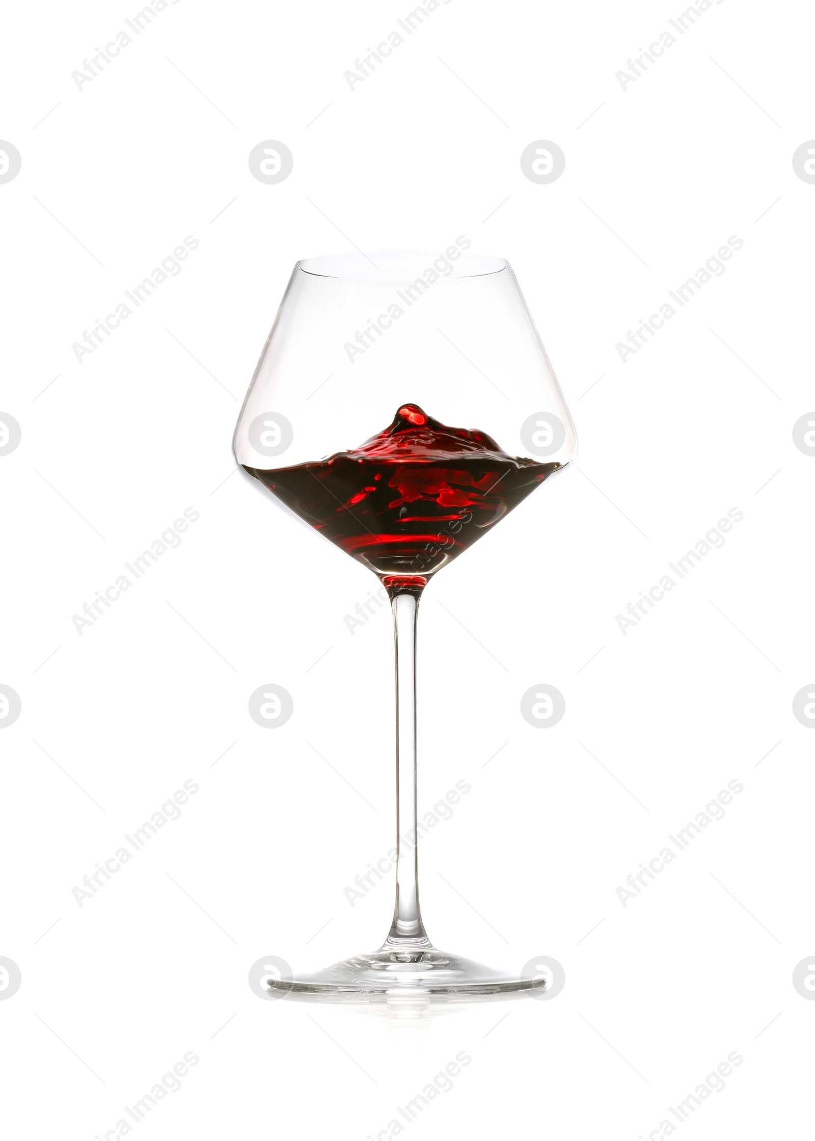 Photo of Red wine splashing in glass on white background