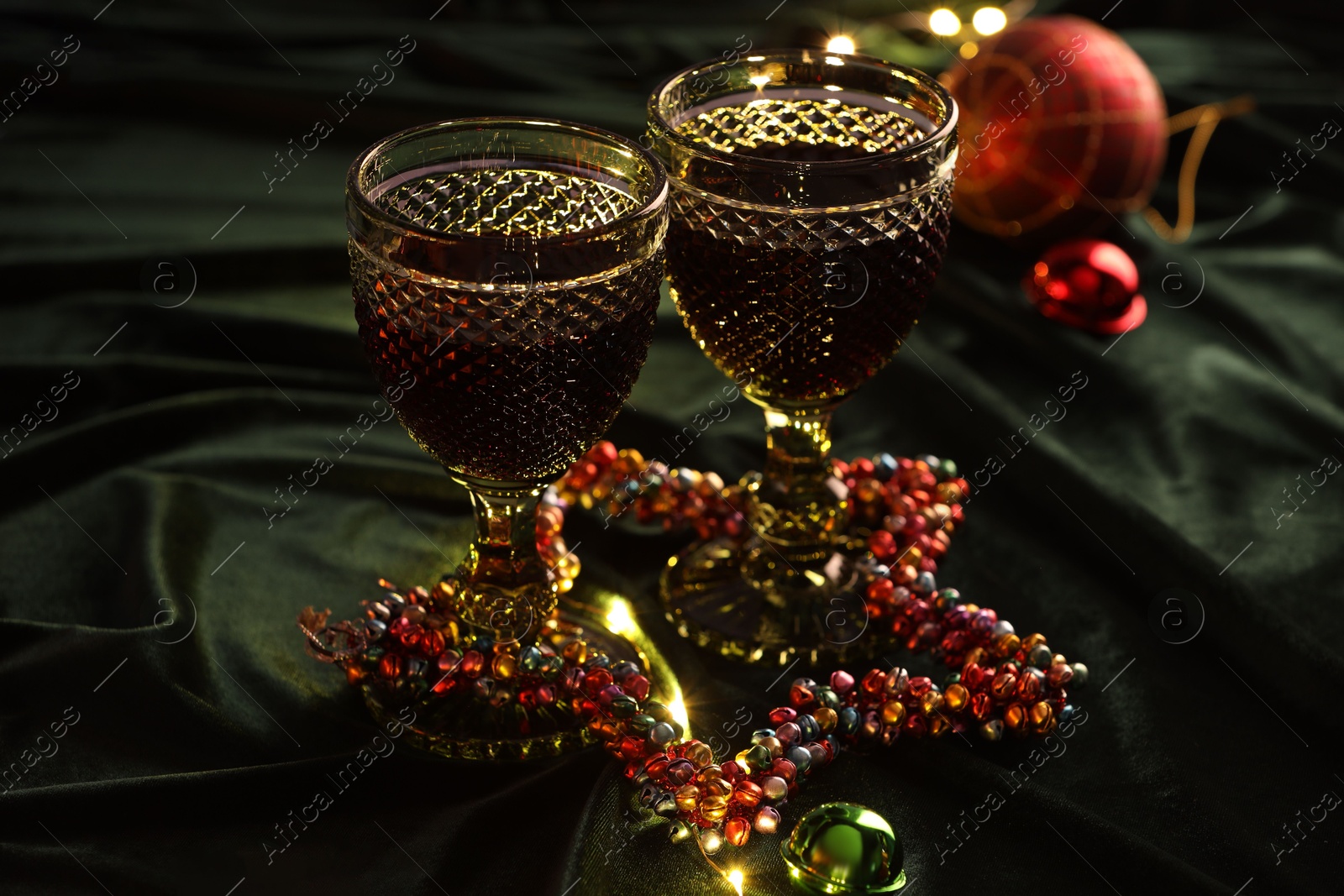 Photo of Glasses with red wine and beautiful Christmas decor on table