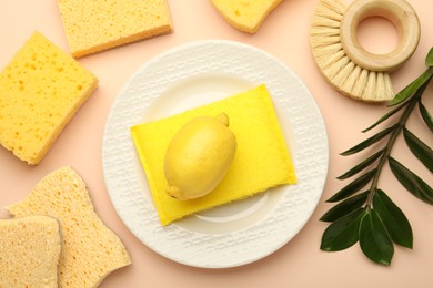 Photo of Flat lay composition with sponges and plate on beige background