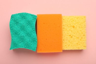 Color sponges on pink background, top view