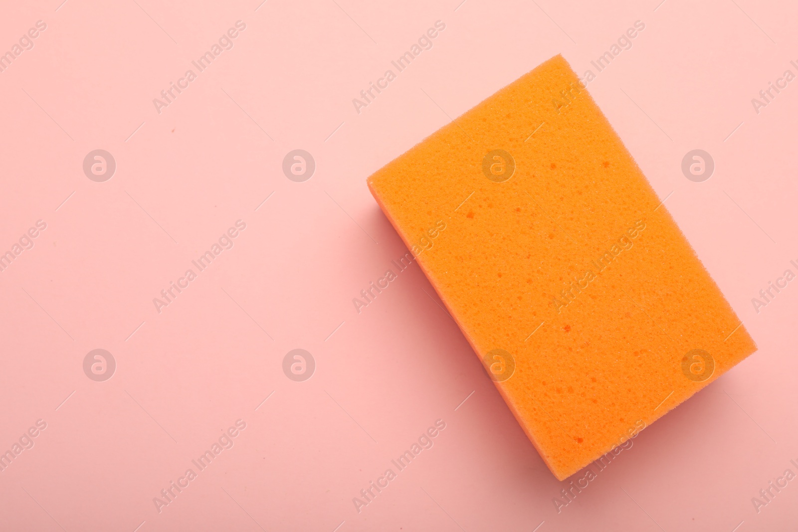 Photo of One sponge on pink background, top view. Space for text