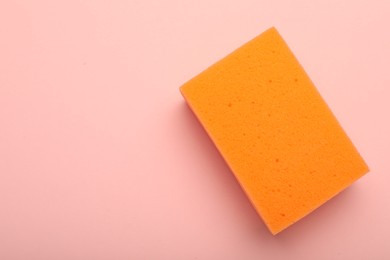 One sponge on pink background, top view. Space for text