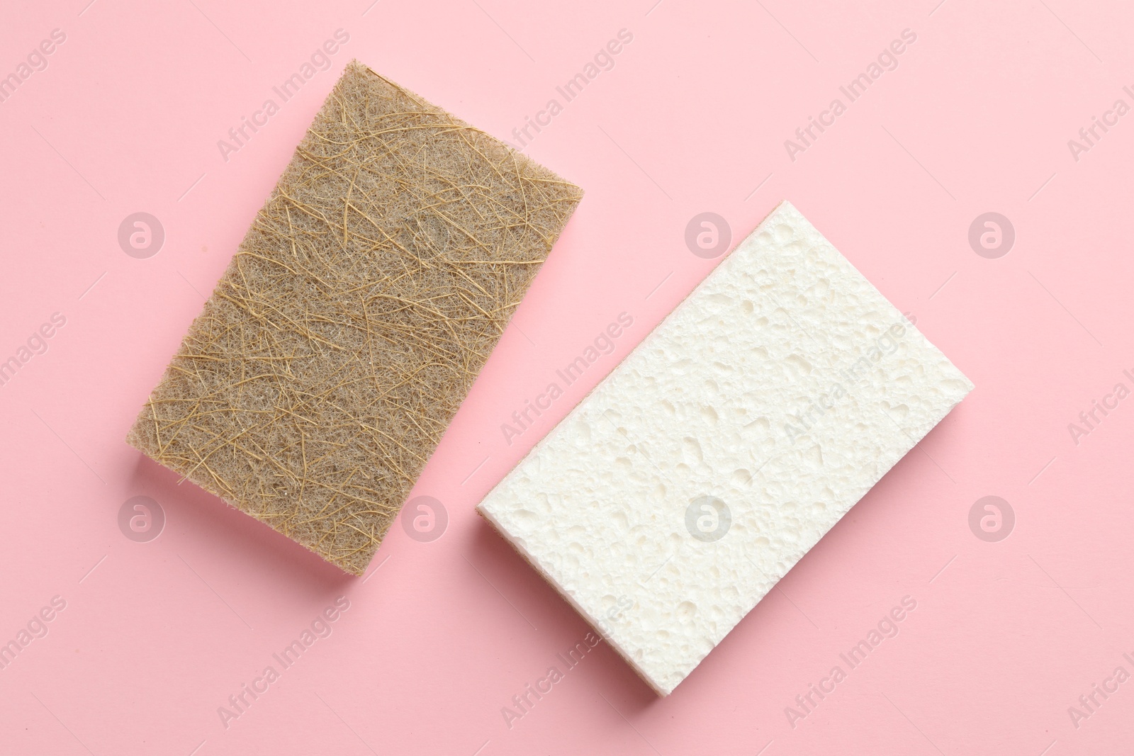 Photo of Two sponges on pink background, top view