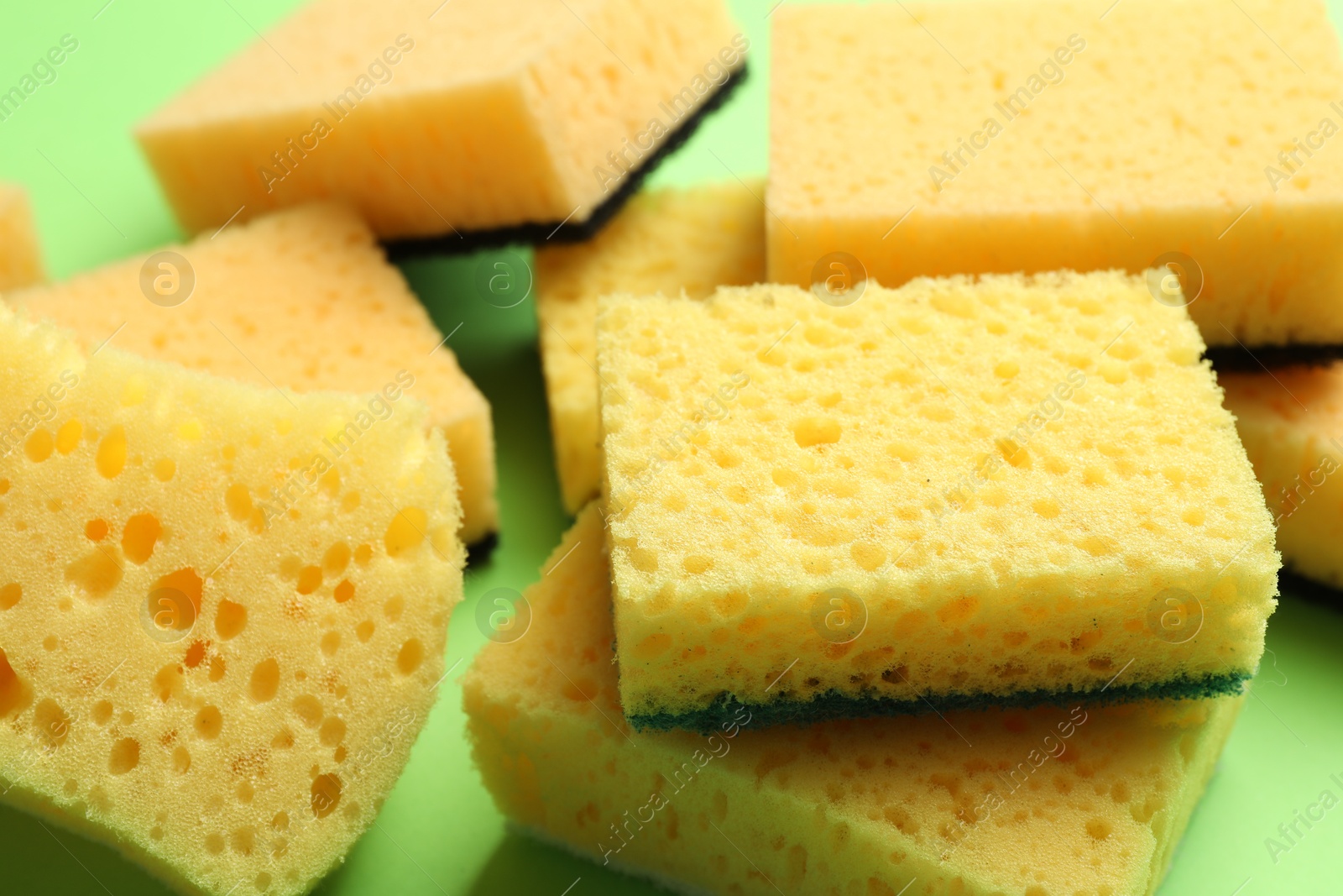 Photo of Pile of sponges on green background, closeup