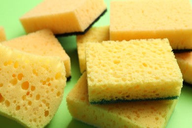 Photo of Pile of sponges on green background, closeup