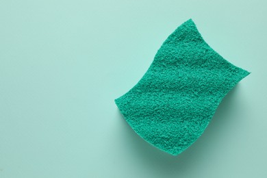 Photo of One sponge on light blue background, top view. Space for text