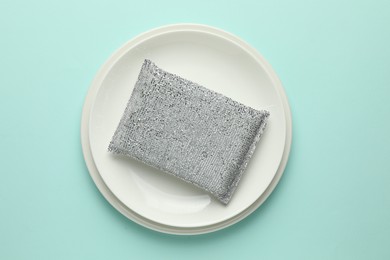 Photo of One sponge and plates on light blue background, top view