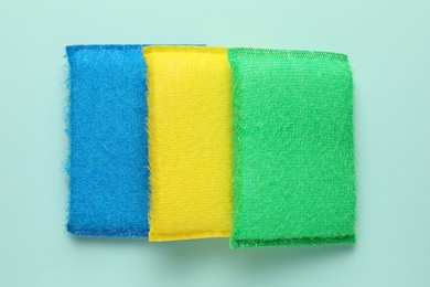 Photo of Color sponges on light blue background, top view