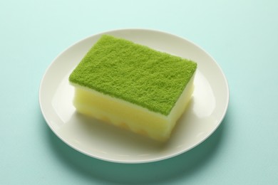 Photo of One sponge and plate on light blue background, closeup