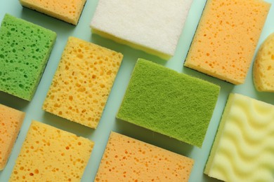 Photo of Color sponges on light blue background, flat lay