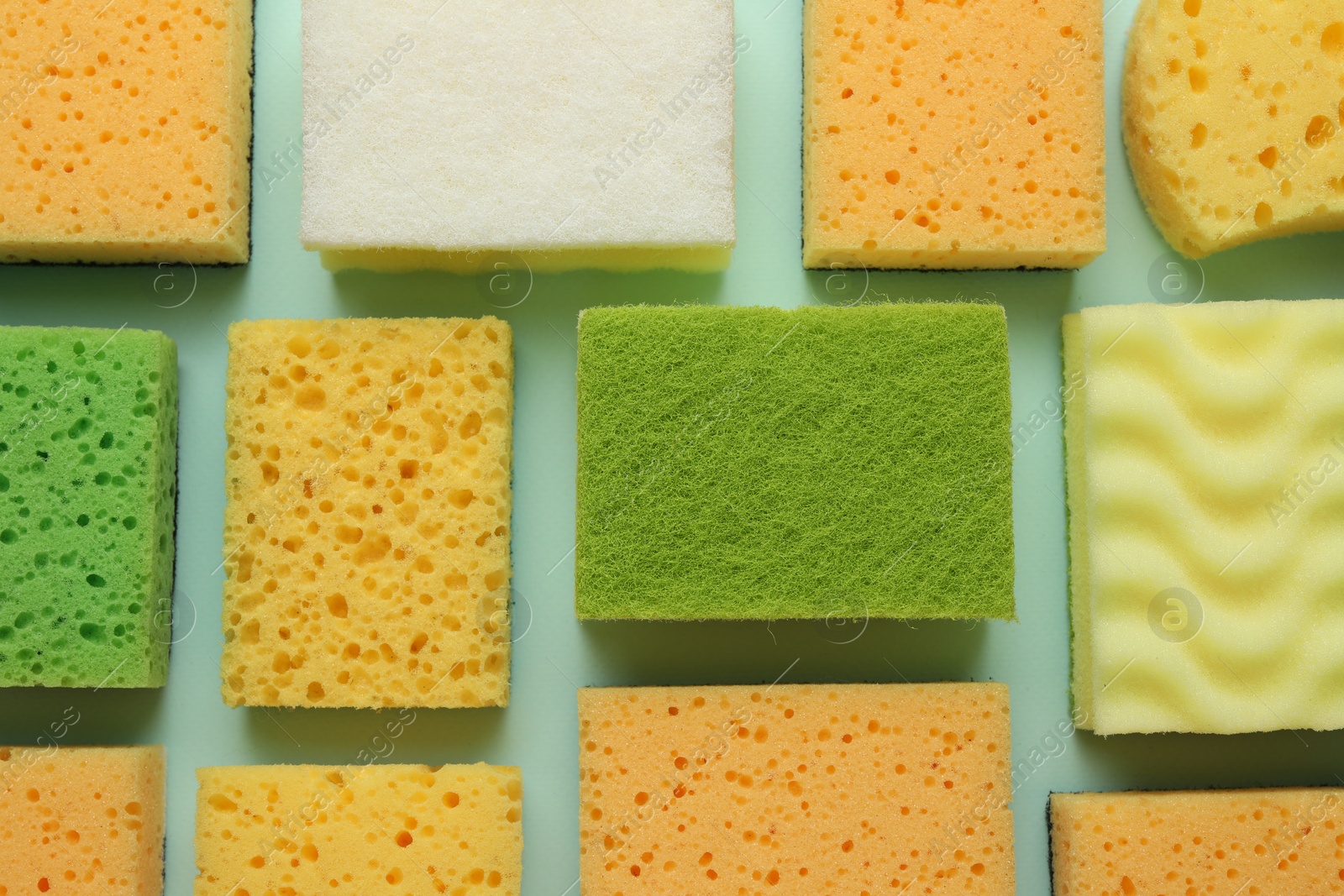 Photo of Color sponges on light blue background, flat lay