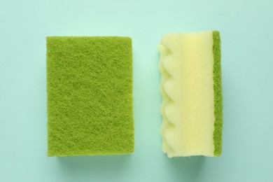 Photo of Colorful sponges on light blue background, top view