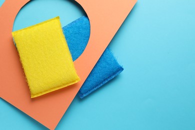 Photo of Flat lay composition with color sponges on light blue background. Space for text