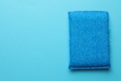 Photo of One sponge on light blue background, top view. Space for text