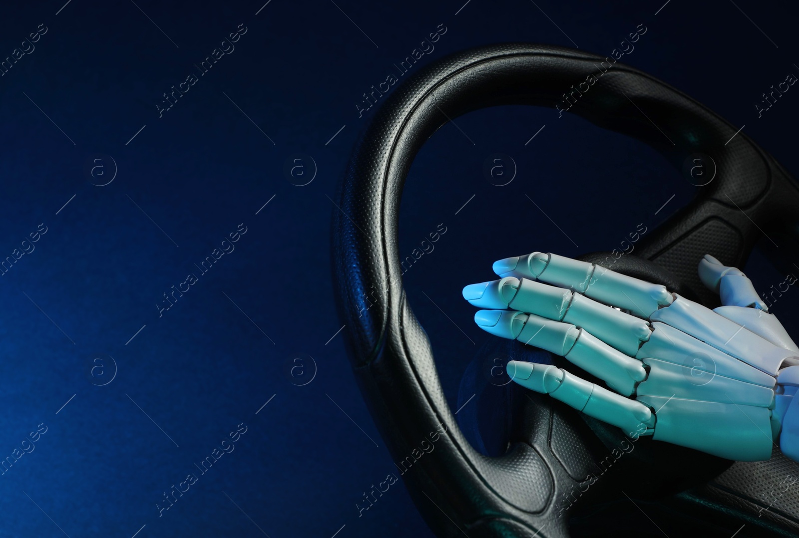 Photo of Artificial intelligence. Robot hand with steering wheel on dark blue background, closeup. Space for text