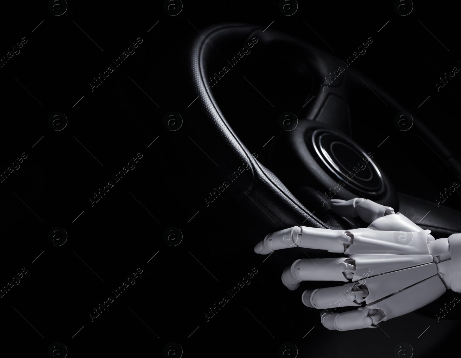 Photo of Artificial intelligence. Robot hand with steering wheel on black background, closeup. Space for text