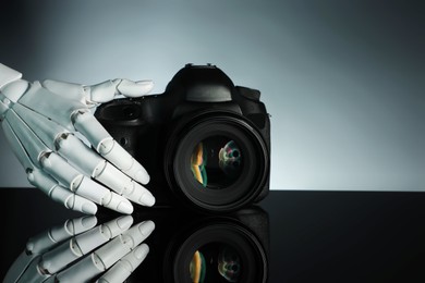 Photo of Artificial intelligence. Robot hand with photo camera against grey background, closeup. Space for text