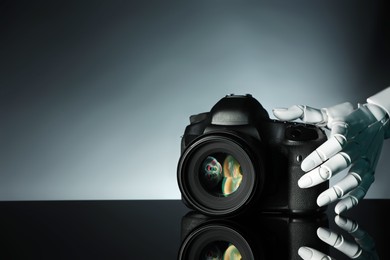 Photo of Artificial intelligence. Robot hand with photo camera against grey background, closeup. Space for text