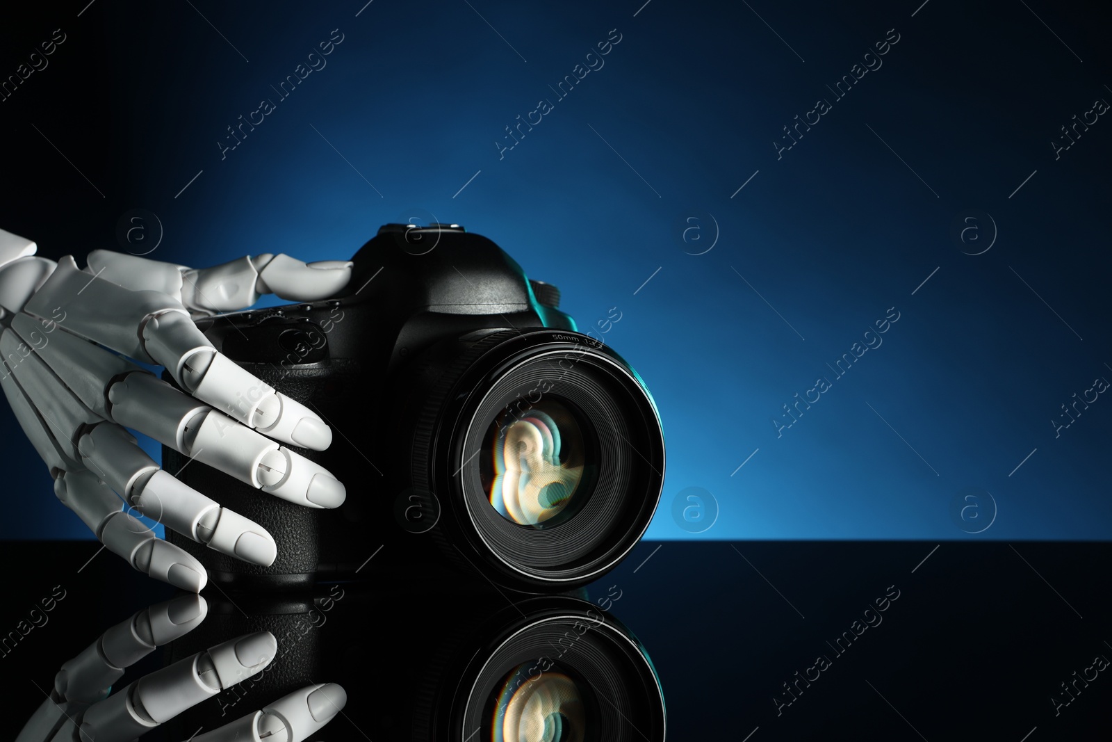 Photo of Artificial intelligence. Robot hand with photo camera against dark blue background, closeup. Space for text