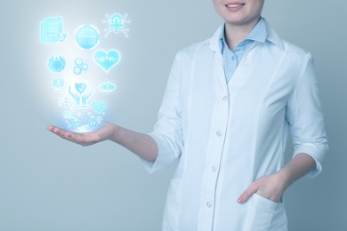 Image of Medical privacy and confidentiality. Doctor with different icons coming out of her hand on light background, closeup