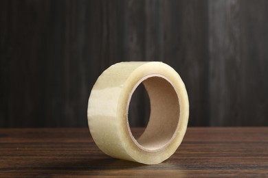 Photo of One adhesive tape on wooden table, closeup